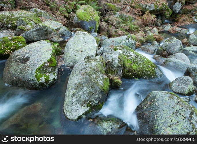 Brook and big rocks with moss in autumn