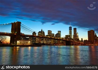Brooklyn Bridge with lower Manhattan skyline in New York City at evening