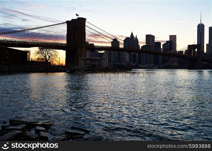 Brooklyn Bridge with lower Manhattan skyline in New York City at evening