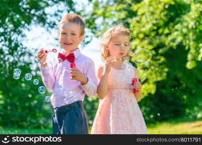 brother and sister 6 years in the park with soap bubbles