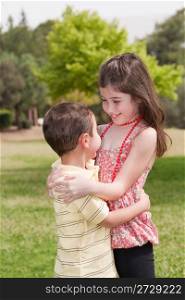 Brother and sister affectionatly hugging in the park,outdoor
