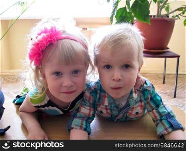 brother and sister, boy and girl cuddling on a bench
