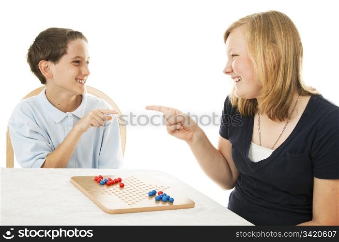 Brother and sister having fun playing board games. Isolated on white.
