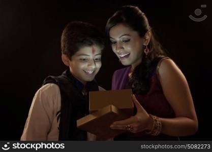 Brother and sister illuminated by light from within gift box