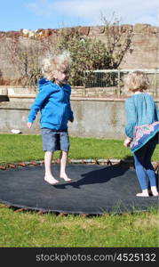 Brother and sister jumping on a trampoline