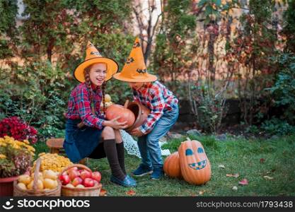 Brother and sister play in the Autumn Garden, surrounded by fruits of vegetables and fruits. Celebrating the Autumn Harvest.. Brother and sister play in the Autumn Garden, surrounded by fruits of vegetables and fruits.