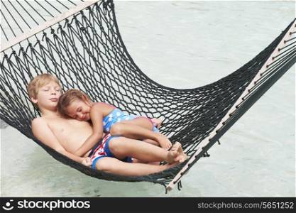 Brother And Sister Relaxing In Beach Hammock