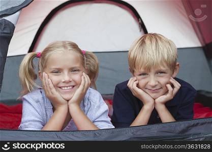 Brother and sister smiling from tent