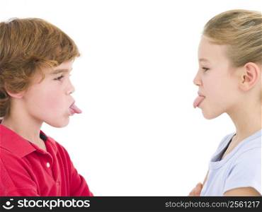Brother and sister sticking tongues out at each other