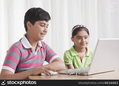 Brother and sister using laptop