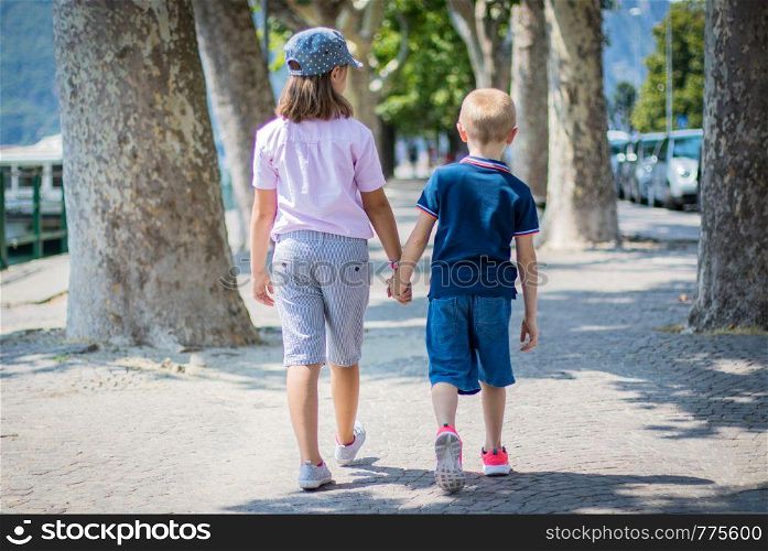 brother and sister walk together shaking hands
