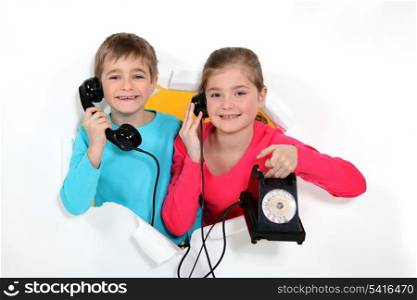 Brother and sister with old-fashioned telephone