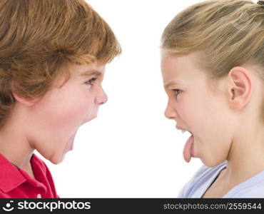 Brother shouting at sister sticking her tongue out