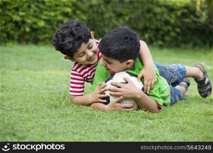Brothers playing with soccer ball in park