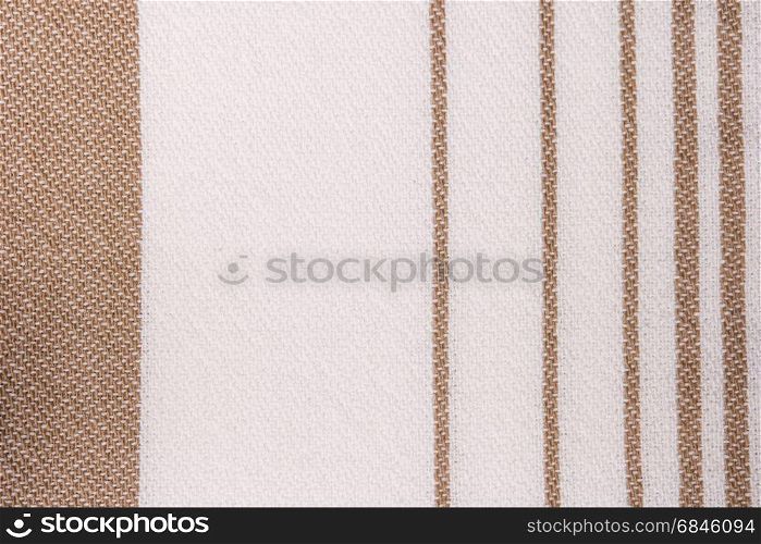 Brown and white striped towel fabric. Tablecloth texture. Cotton texture closeup, background