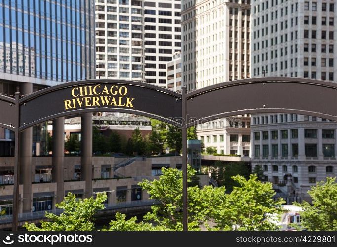 Brown arched sign to Chicago Riverwalk with tribune tower in background
