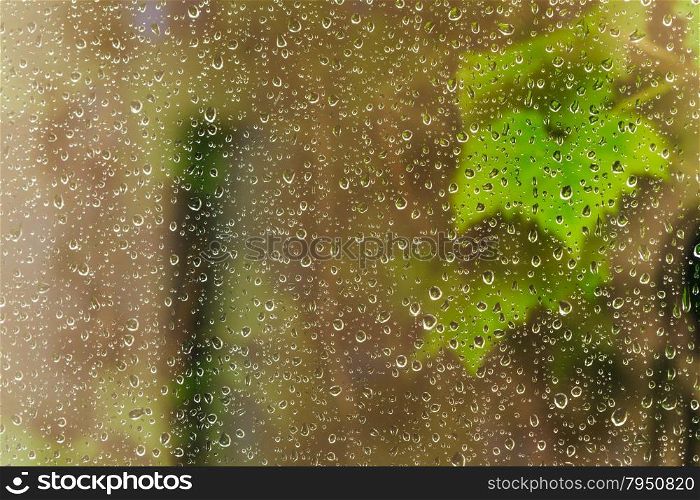 brown background from raindrops on window pane during night rain