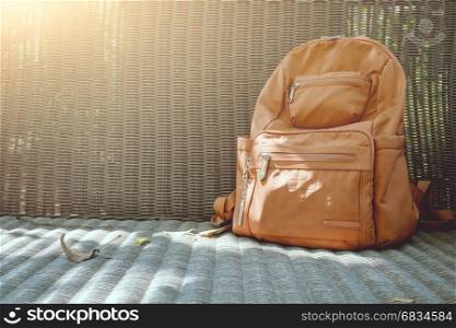 Brown backpack on wicker chair