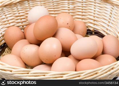 Brown basket with a lot of hen eggs