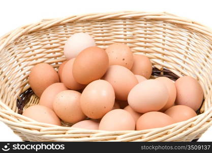 Brown basket with a lot of hen eggs isolated over white