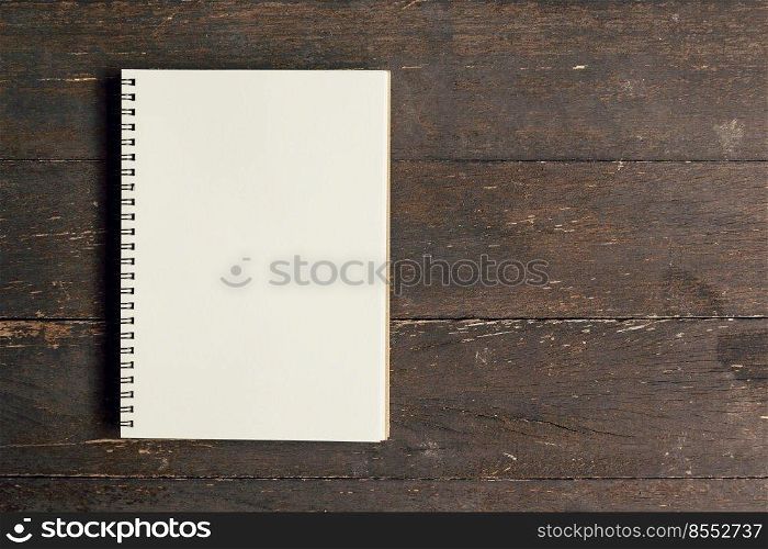 Brown book open on wood table background with space.
