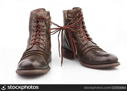 Brown boots connected by the laces, isolated