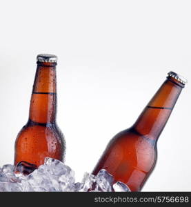 brown bottles of beer chilling on ice
