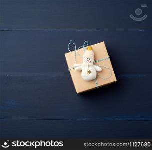 brown cardboard gift square box on a blue wooden background, top view. Festive concept, copy space