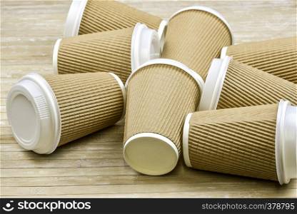 Brown cardboard take away disposable paper cups with white lid.