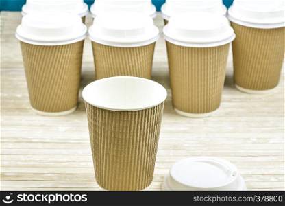 Brown cardboard take away disposable paper cups with white lid.