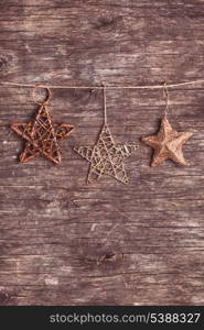 Brown christmas decorations attached to the rope, over wooden background