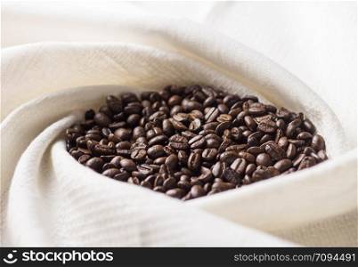 brown coffee bean on white fabric, close up