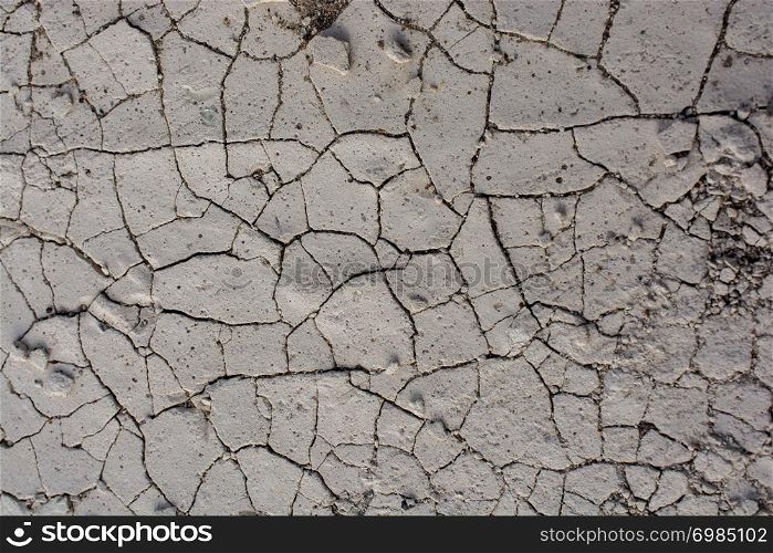 Brown color dry cracked muddy earth as a background texture
