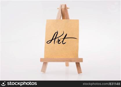 Brown color notepaper on a painting tripod on white background