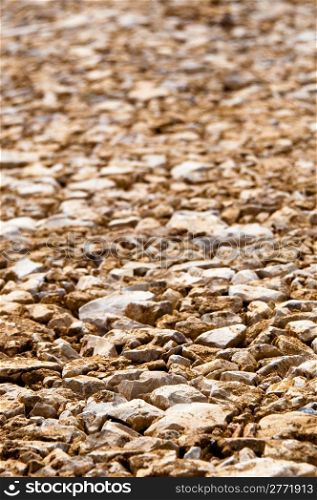 Brown construction site gravel background - the large stones are flattened by heavy machinery