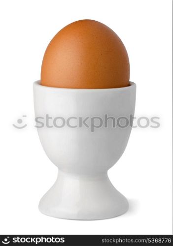 Brown egg in egg cup isolated on white