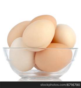 Brown eggs in transparent bowl isolated on white background.