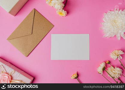 brown envelope, pink giftbox with blank card and flower on pink background