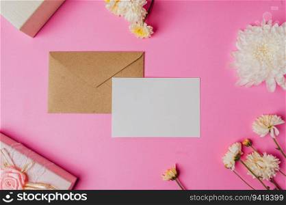 brown envelope, pink giftbox with blank card and flower on pink background