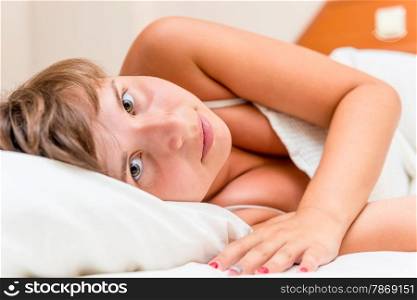 brown-eyed brunette lying in bed in the morning