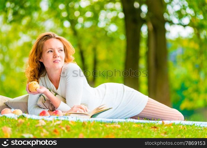 brown-eyed girl with an apple in a summer park