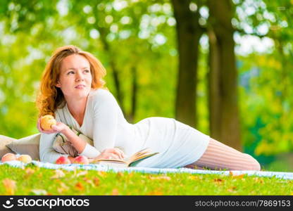 brown-eyed girl with an apple in a summer park