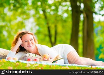 brown-eyed girl with apples and a book in the park