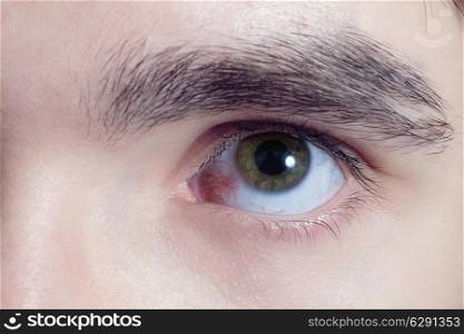 brown eyes of young men with red blood vessels macro