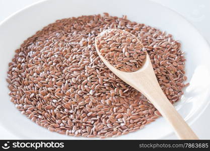 Brown flax seeds on a wooden spoon, stock photo
