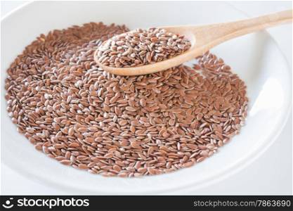 Brown flax seeds on a wooden spoon, stock photo