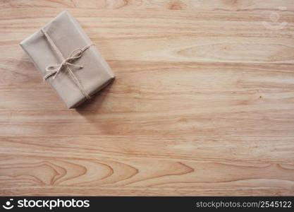 Brown gift box on wooden table background with copy space