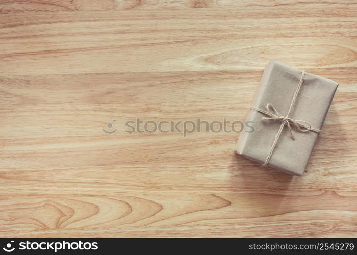 Brown gift box on wooden table background with copy space