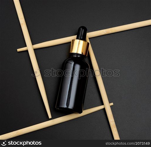 brown glass bottle pipette on a black background. Pharmacy concept. Collagen skin. Mockup skincare cosmetic product