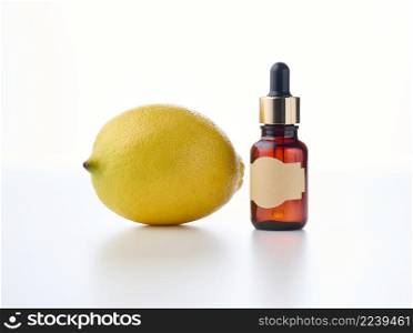 brown glass bottle with a pipette and an empty pasted paper label, lemon. Natural cosmetics on a white background